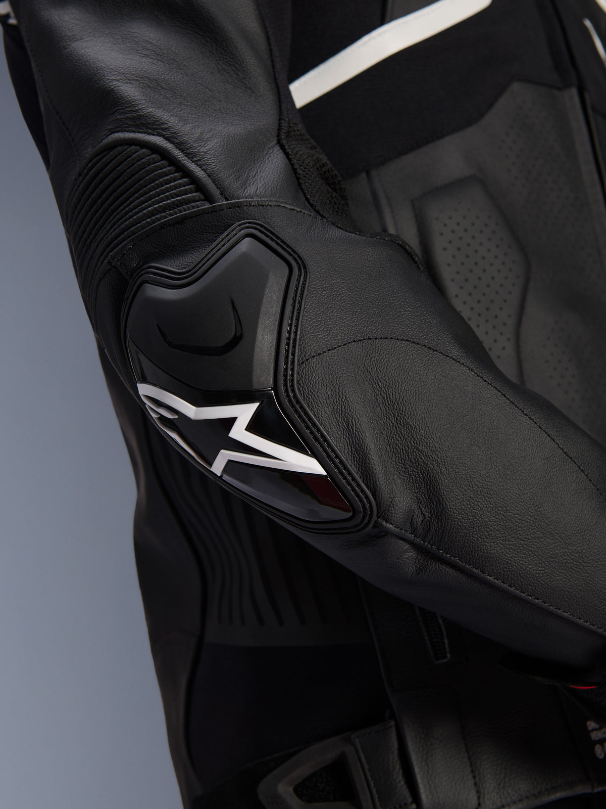 Alpinestars Atem V5 Leather Jacket, Black and White, close-up of the DFS RR elbow protector with white star logo, featuring accordion leather and perforated textures for sport riding