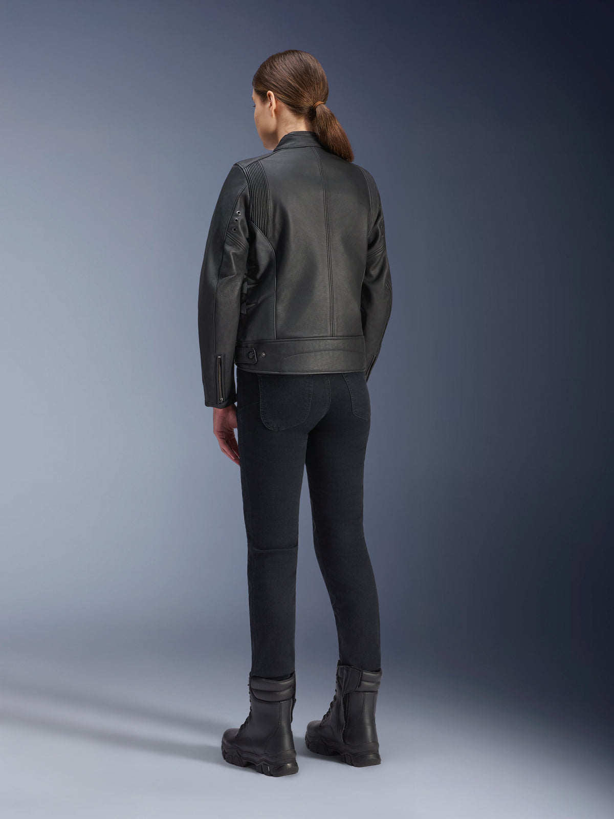 Alpinestars Stella Dyno læderjakke, motorcykeljakke til damer, sort, set bagfra, premium læderkonstruktion og skræddersyet pasform, båret med sorte motorcykelbukser og sorte støvler, urban kørestil