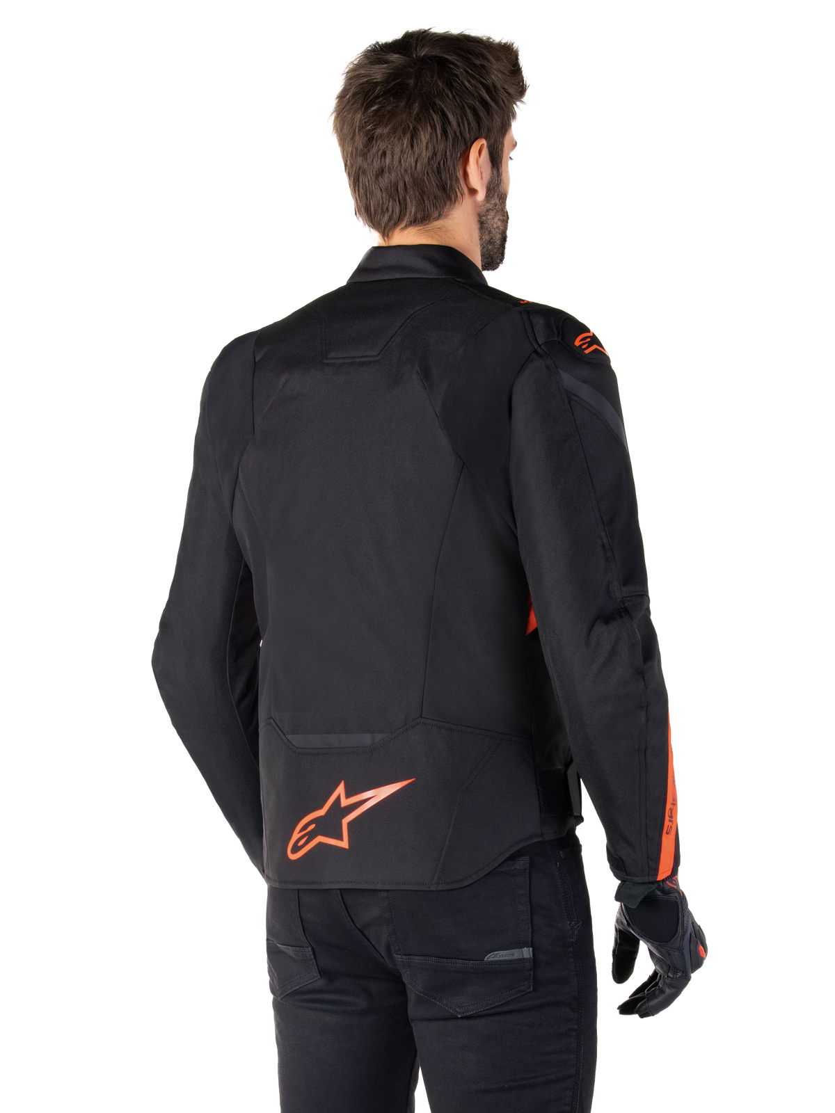 Mandlig model iført Alpinestars T-Jaws V4 Waterproof-jakke set bagfra, sort med røde fluo-detaljer, med et rødt fluo-logo nederst på ryggen og detaljer på skuldre og ærmer, sportsmotorcykeludstyr