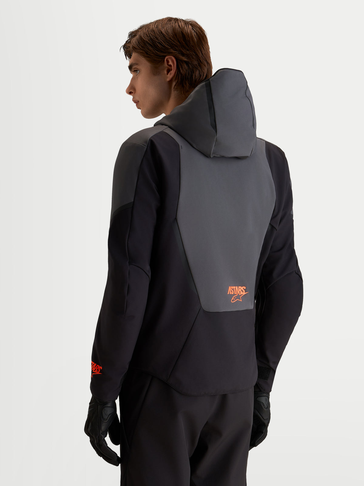 Alpinestars Aeroshell vandtæt motorcykeljakke, herre softshell i sort og mørkegrå, set bagfra med integreret hætte og rygpanel