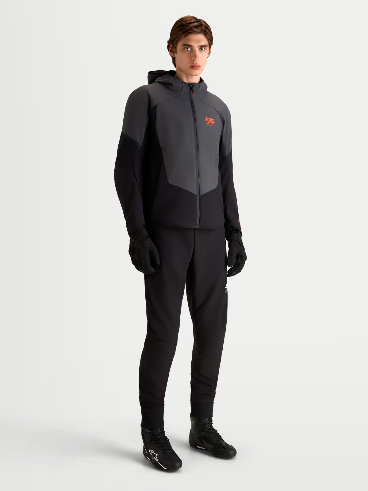 Alpinestars Aeroshell WP jakke, herre-motorcykelsoftshelljakke i sort og mørkegrå med CE-certificeret beskyttelse og adaptiv stretch-skal, båret af en model