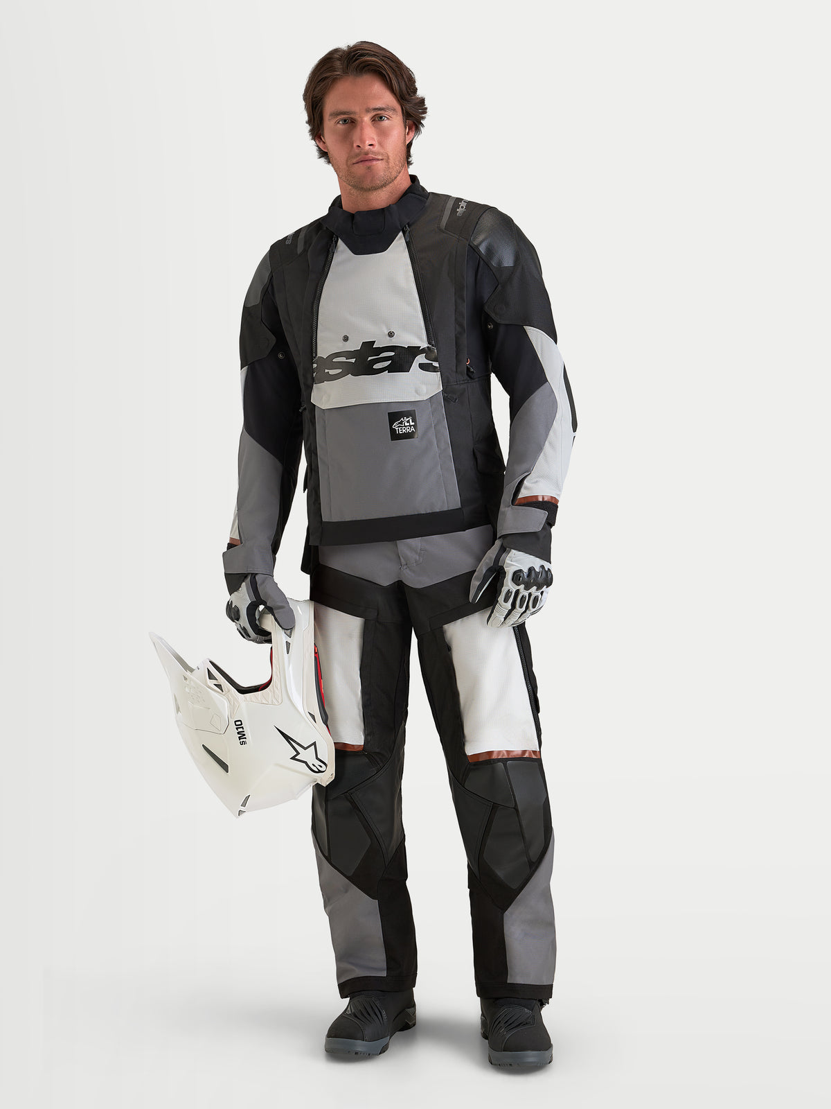 Alpinestars Harok V2 Drystar jakke, herre-motorcykeljakke til adventure og off-road, mørkegrå, isgrå og sort, vandtæt tekstilkonstruktion med CE-certificeret beskyttelse, båret af mandlig model med hvid hjelm