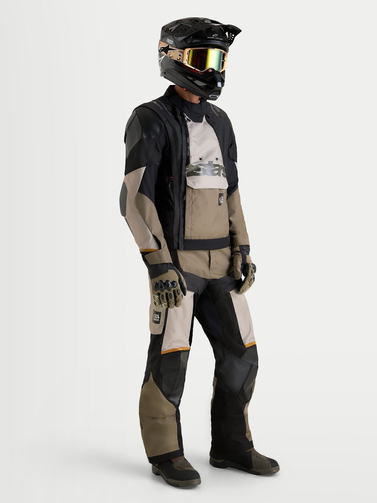 Alpinestars Harok V2 Drystar Gear Set, adventure touring motorcycle jacket and pants in black and khaki, worn by a model with a matching helmet and goggles, showcasing all-weather waterproof textile construction