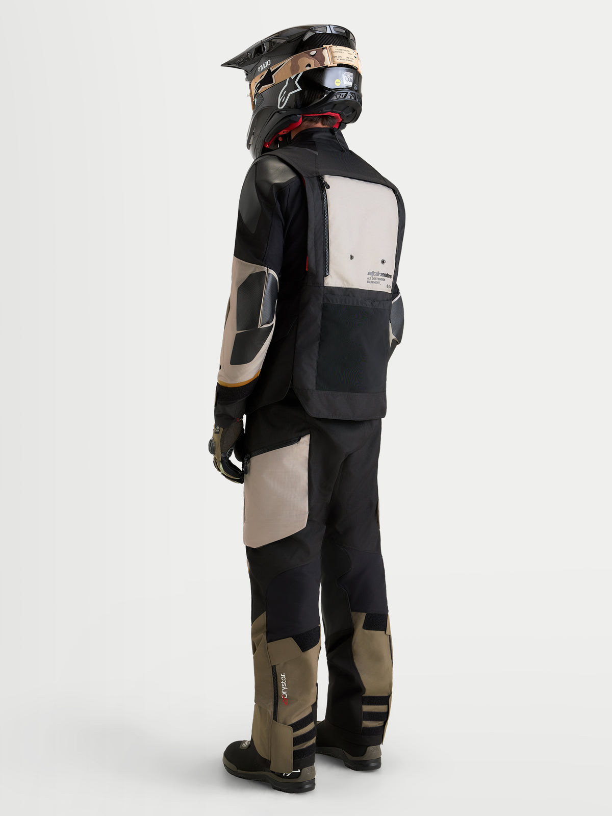 Alpinestars Harok V2 Drystar Gear Set, adventure touring motorcycle jacket and pants in black and khaki, rear three-quarter view on a model wearing matching gear and helmet, all-weather waterproof riding apparel