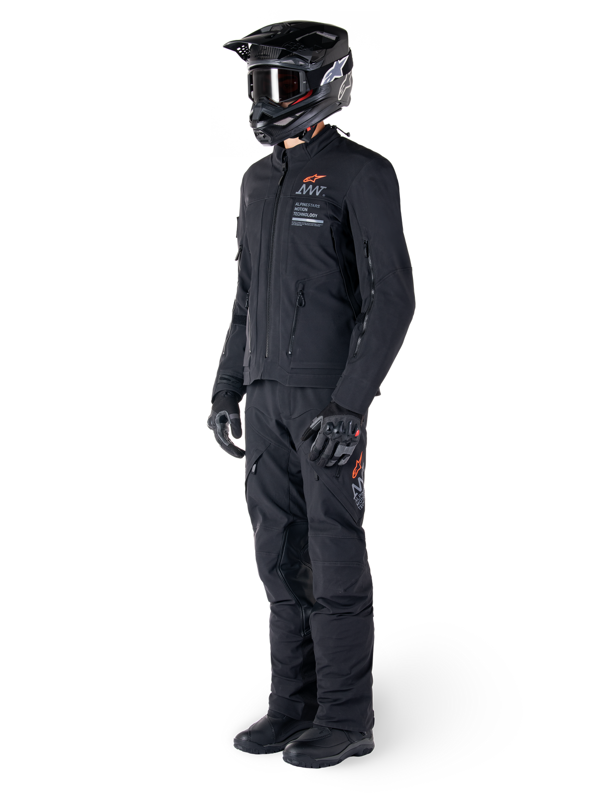 Alpinestars AMT-8 Stretch Drystar® XF-jakke, adventure-motorcykeljakke, sort, vist med matchende bukser, hjelm og handsker, med Alpinestars Motion Technology-branding og orange detaljer, slidstærk strækkonstruktion til adventure-kørsel
