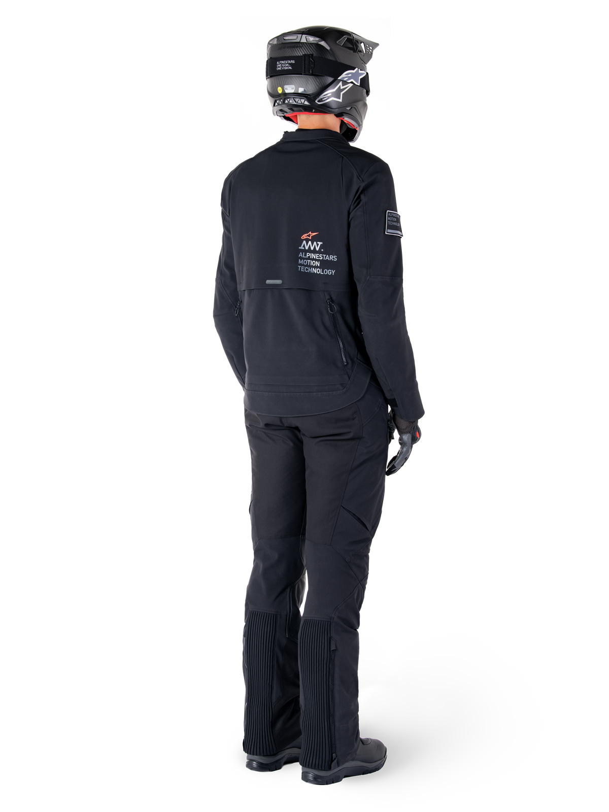 Alpinestars AMT-8 Stretch Drystar® XF jakke, sort, set bagfra af en kører iført jakken med matchende sorte bukser og en sort hjelm, med 'Alpinestars Motion Technology' branding på ryggen, teknisk strækmateriale til adventure-motorcykelkørsel