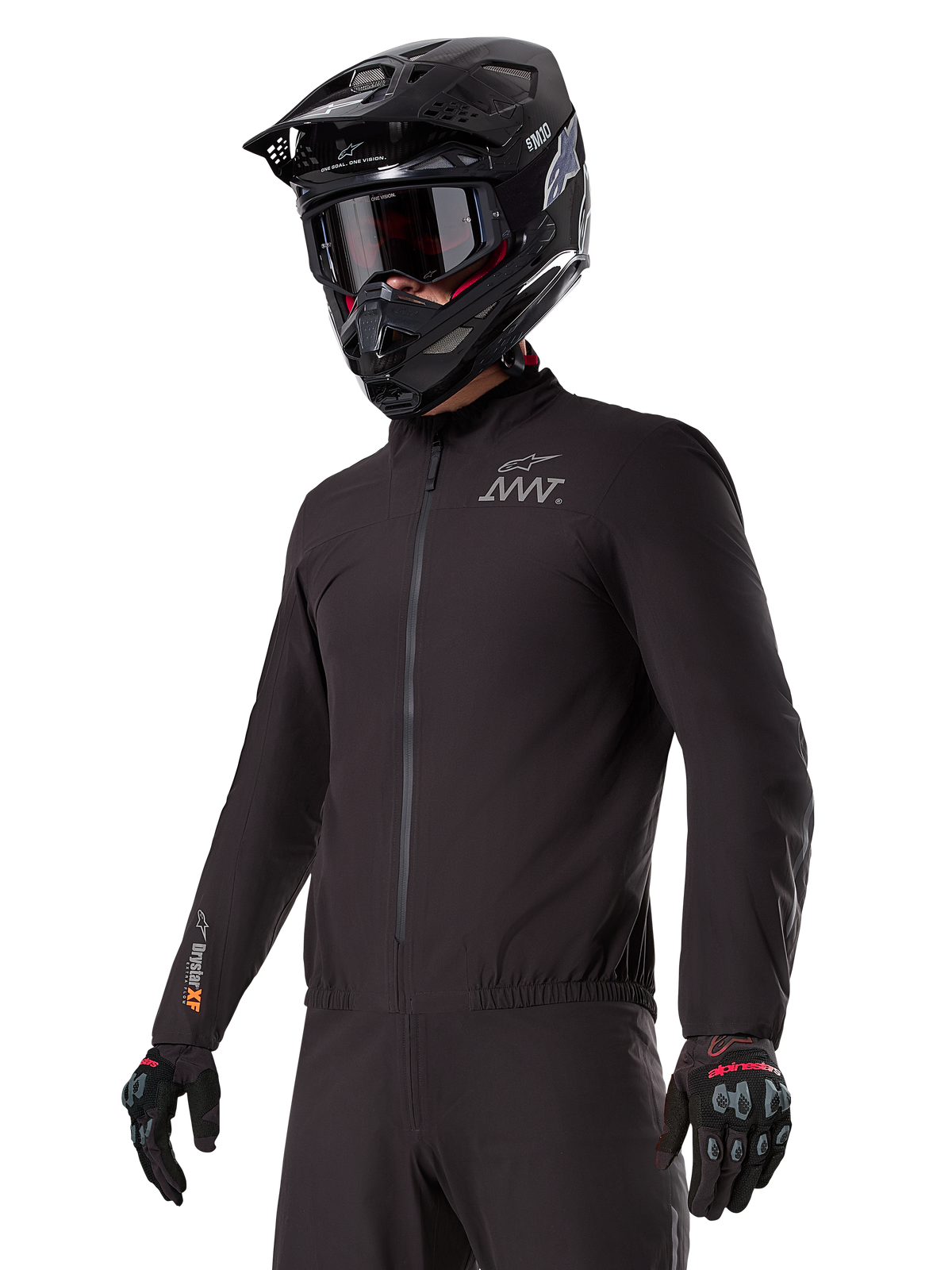 Motorcyklist iført Alpinestars AMT-8 Stretch Drystar® XF Liner, sort vindtæt og vandtæt strækjakke med AMT-logo på brystet og Drystar XF-branding på ærmet, kombineret med en sort adventure-hjelm og beskyttelseshandsker.