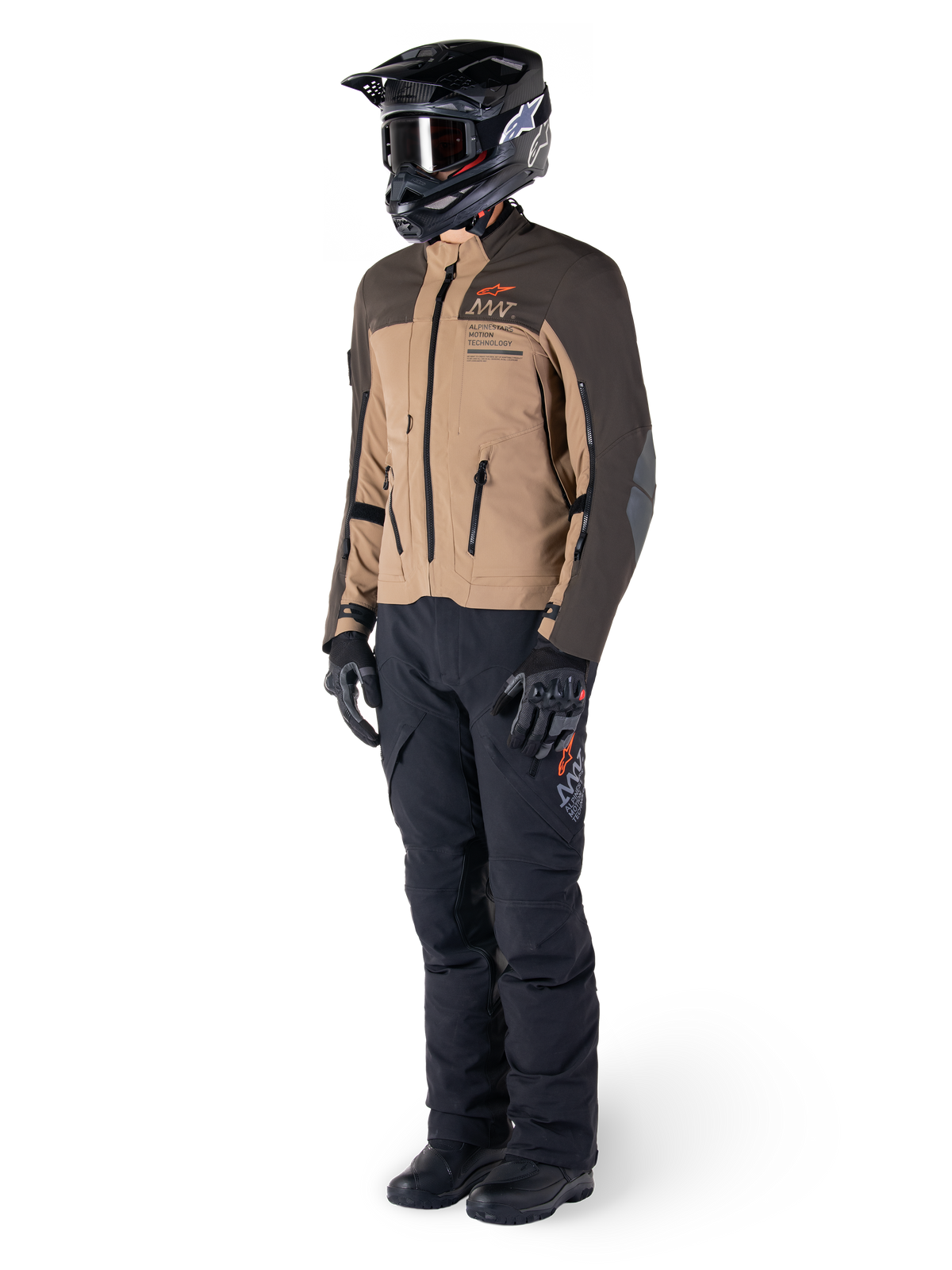 Adventure-rytter iført komplet udstyr, Alpinestars AMT-8 Stretch Drystar® XF-jakke i mørkebrun og mørk khaki, kombineret med sorte adventure-bukser, sort hjelm, handsker og støvler, med orange AMT-branding og tekniske ventilationslynlåse til langdistance-touring