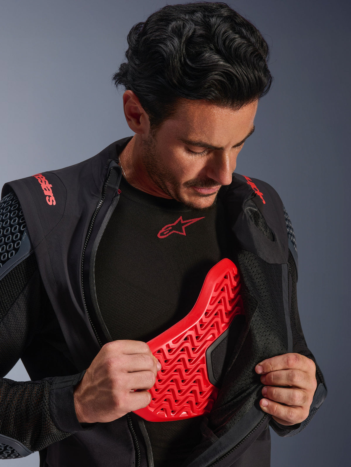 Alpinestars Halo Pro Drystar® XF lamineret jakke i Black Dark Shadow, båret af en model, lynet ned for at afsløre en rød Nucleon Flex Pro brystbeskytter, teknisk motorcykeljakke med integreret beskyttelse, adventure køreudstyr