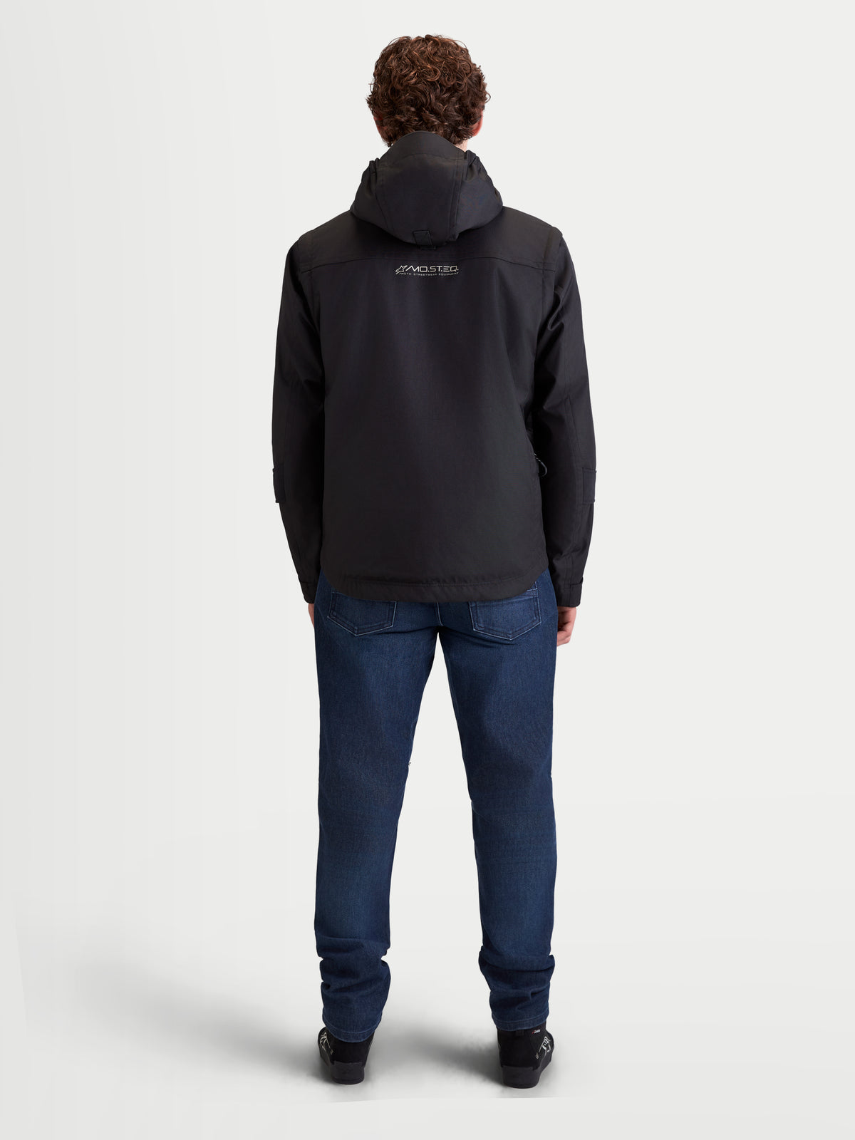 Alpinestars Morfex Parka Waterproof Jacket, herre-motorcykeljakke i sort set bagfra, model iført jakke med integreret hætte og casual jeans