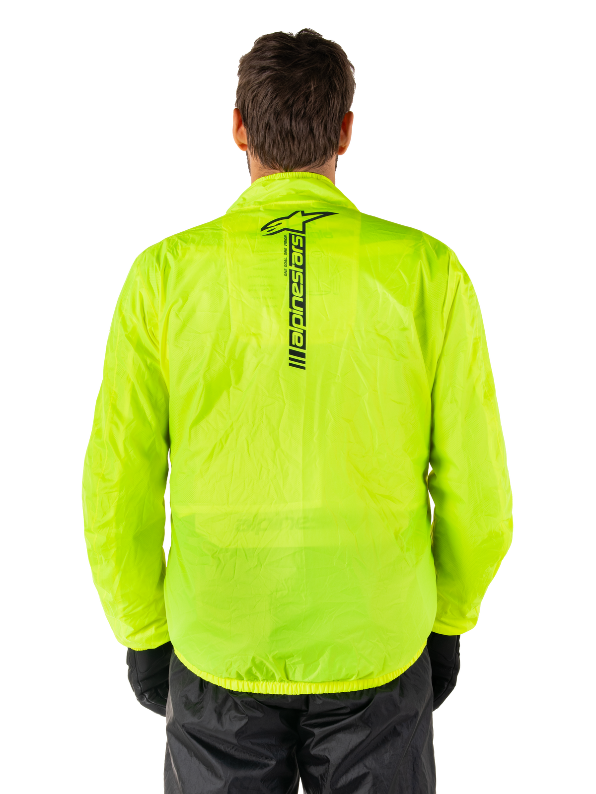 Alpinestars Hurricane Rain V2-jakke, regnjakke til motorcykel, Yellow Fluo, set bagfra viser lodret sort Alpinestars-logo midt på ryggen, let vandtæt materiale, båret med sorte kørebukser og handsker