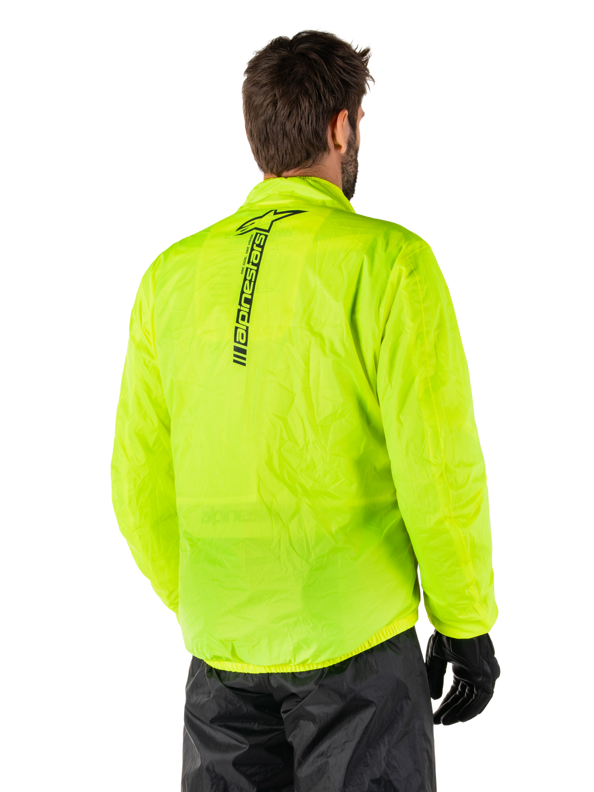 Alpinestars Hurricane Rain V2 Jakke, Yellow Fluo, set bagfra på mandlig model, lodret sort Alpinestars-ordmærke på ryggen, elastik i talje og manchetter, vandtæt og sammenpakbart design