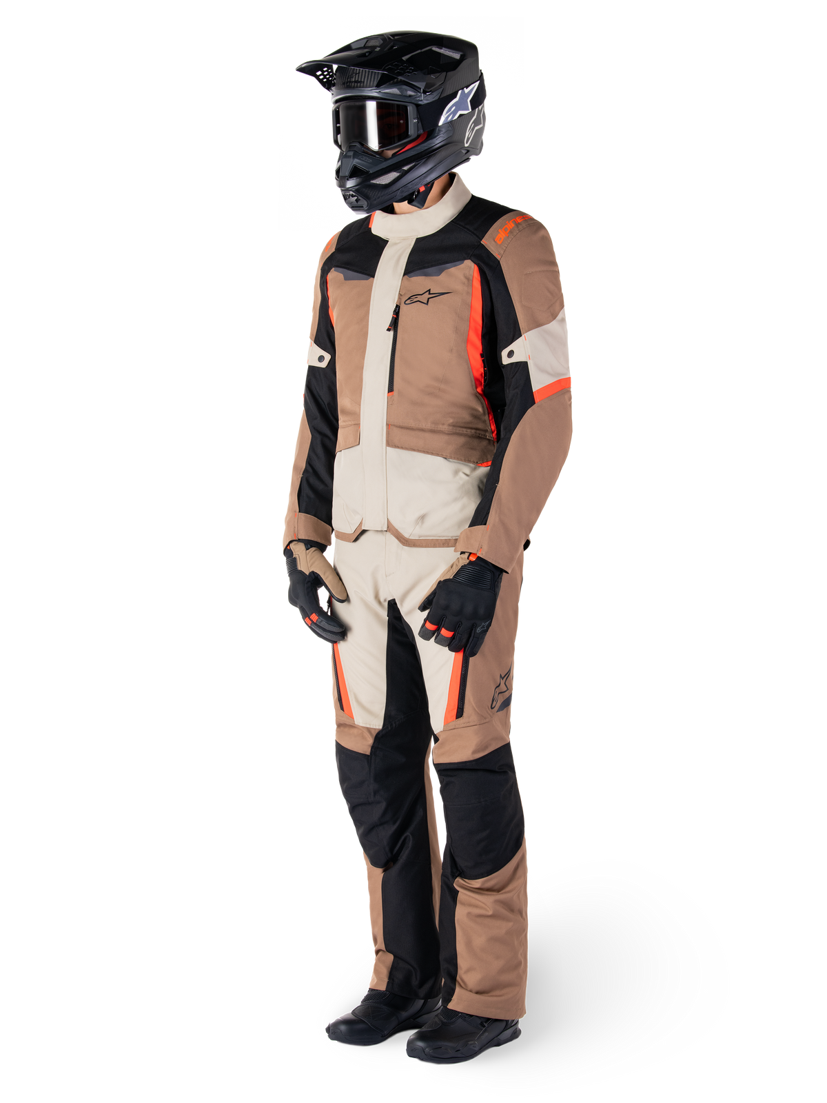 Alpinestars ST-1 vandtæt jakke, mørk khaki, sand, sort og rød fluo, båret af en kører i fuldt adventure touring-udstyr med matchende bukser, sort hjelm, briller, handsker og støvler, teknisk motorcykeloutfit til al slags vejr