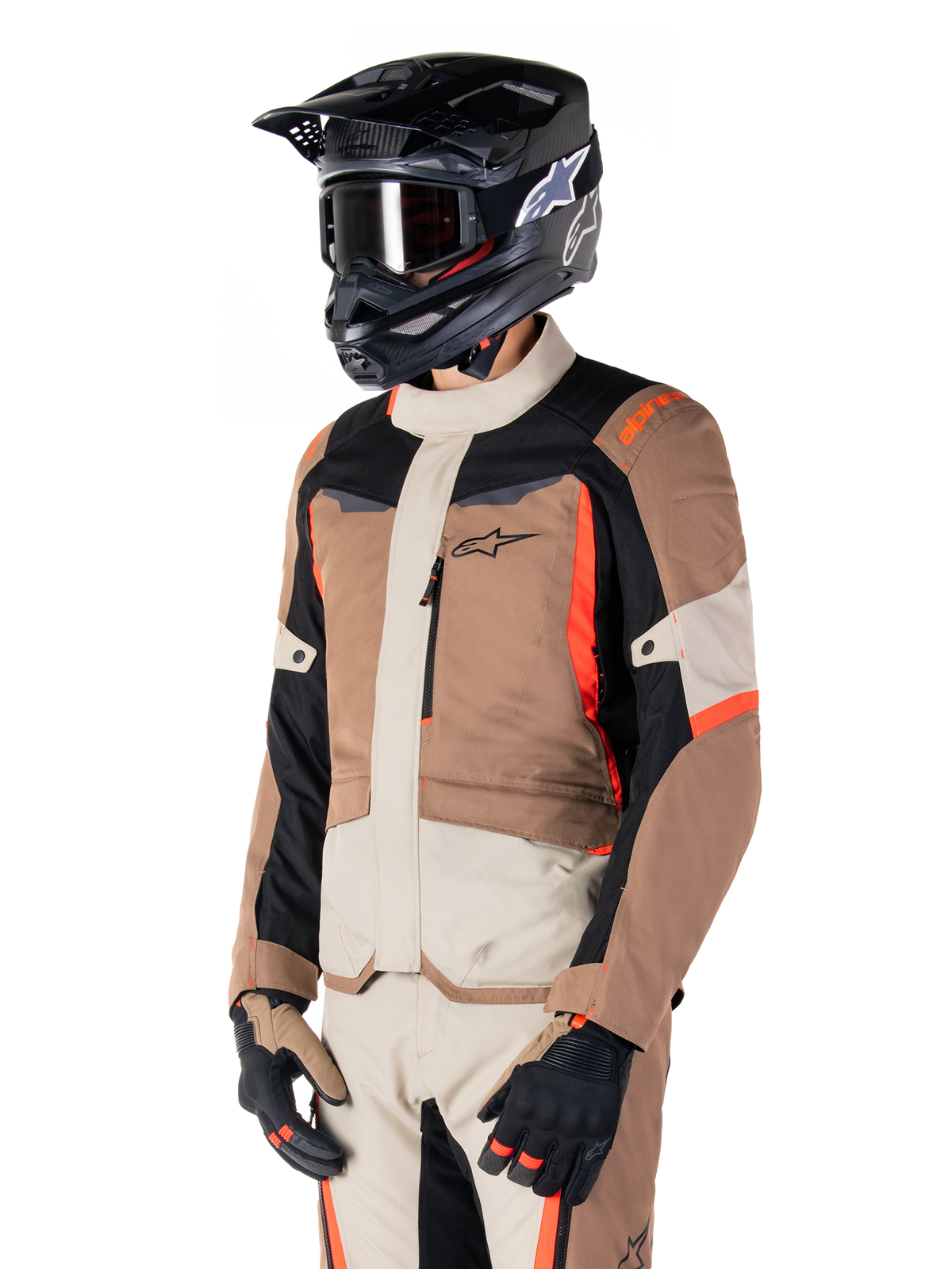 Alpinestars ST-1 vandtæt jakke, adventure touring-jakke, mørk khaki, sand, sort og rød fluo, bæres af en kører med en sort motocrosshjelm og briller, design med flere paneler, cargo-lommer og Alpinestars-branding på brystet
