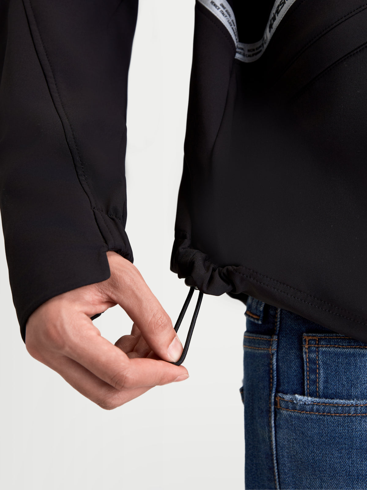 Alpinestars C-5 Drystar Jacket, men's urban motorcycle textile jacket in black, close-up view showing the lower hem shock cord adjustment and elasticated cuff