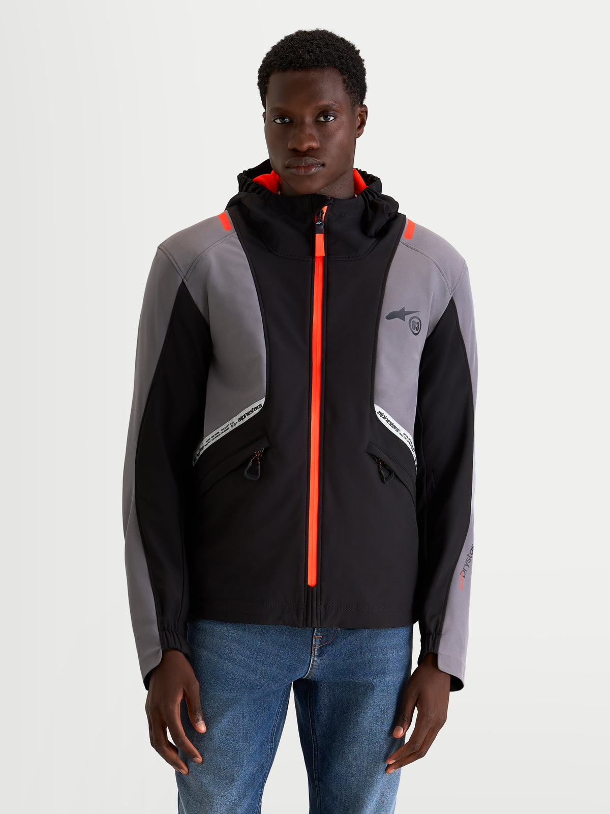 Alpinestars C-5 Drystar jakke, herre urban motorcykeltekstiljakke i sort og mørkegrå, set forfra på en model der viser vandtæt softshell-konstruktion, integreret hætte og lyse orange lynlåsdetaljer