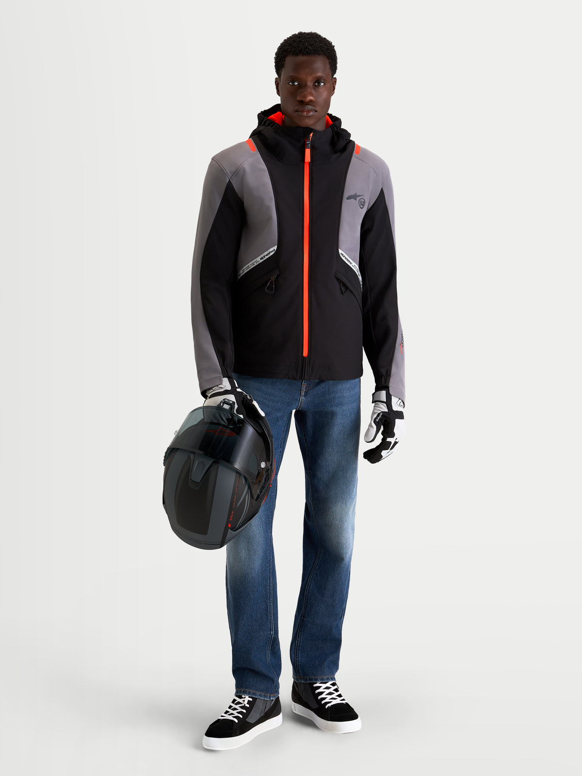 Alpinestars C 5 Drystar jakke, herre urban contemporary motorcykeljakke i sort og mørkegrå, set forfra på model iført jeans, handsker og hjelm, hvor han holder en hjelm