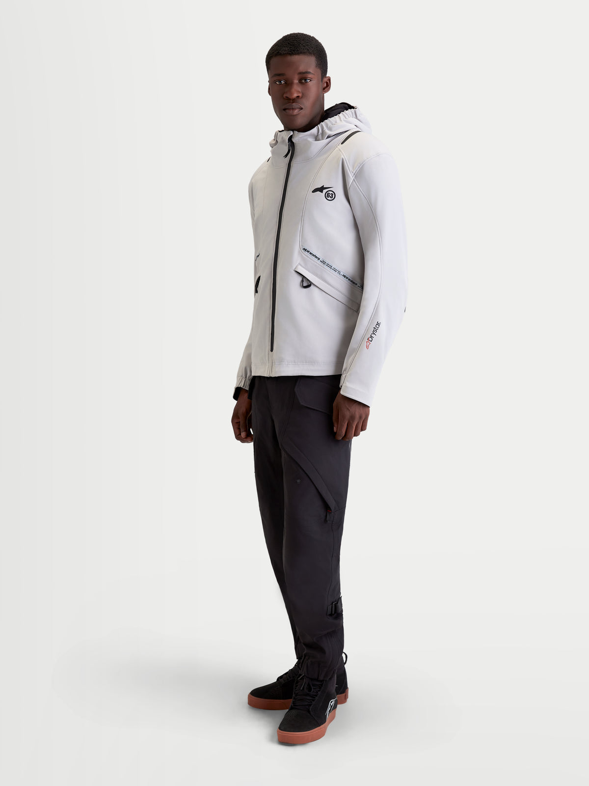 Alpinestars C 5 Drystar Jakke, herre urban motorcykeltekstiljakke i lys grå og sort, båret af model der viser den vandtætte softshell-konstruktion, integrerede hætte og beskyttelsesfunktioner