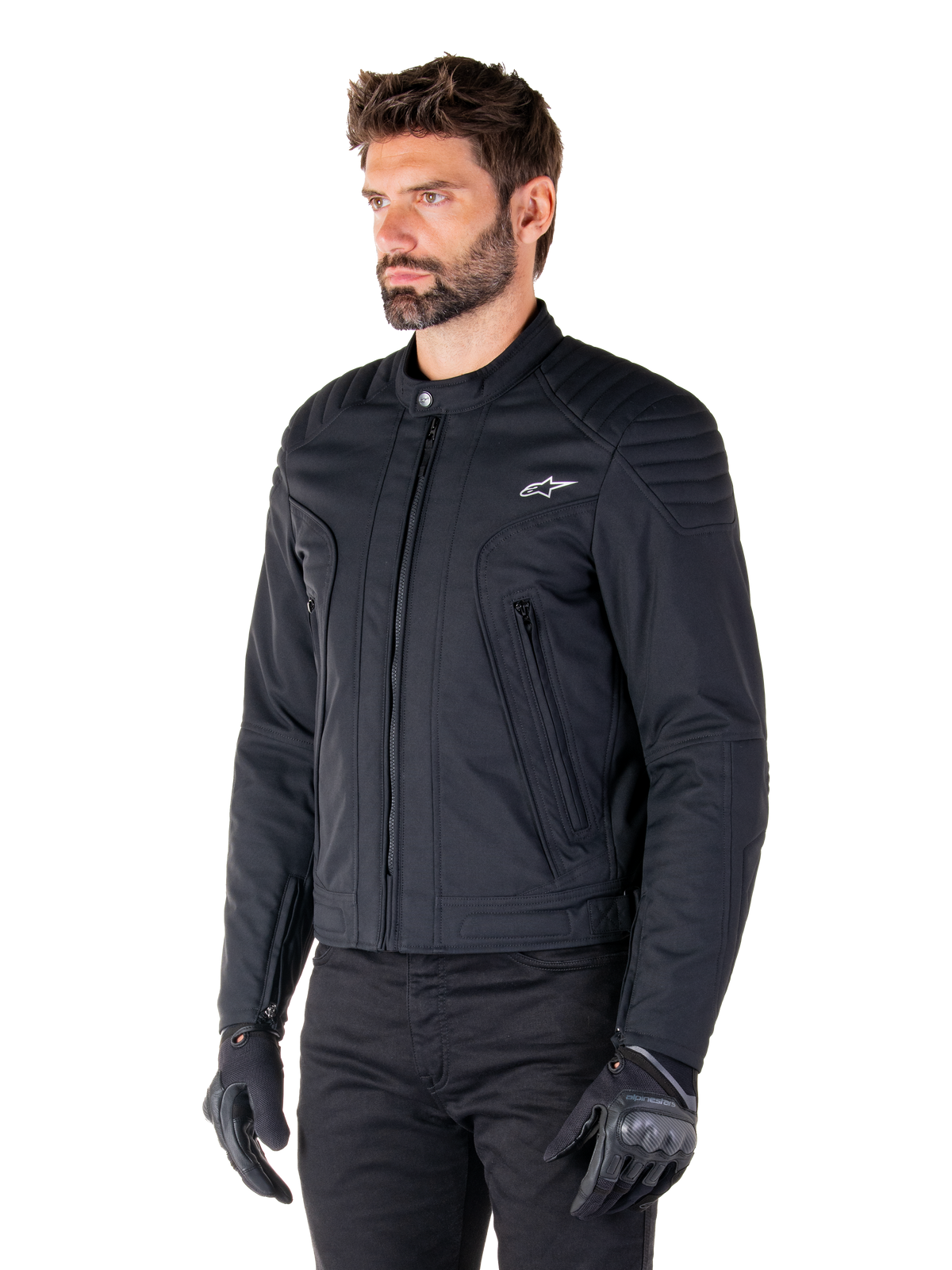 Alpinestars Clayton WR Jakke, sort, urban motorcykeljakke i tekstil med quiltede detaljer på skuldre og underarme, slim-fit design, mat finish, båret af en kører med sorte handsker.