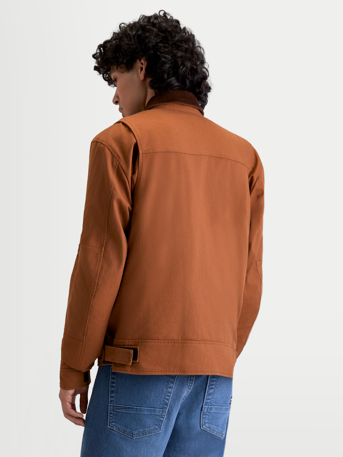 Alpinestars Mustang WP jakke, herre-motorcykeljakke i mørk rust og mørkebrun, set bagfra på en model, der viser arbejdstøjsinspireret stretch-twill-konstruktion og skulderkiler