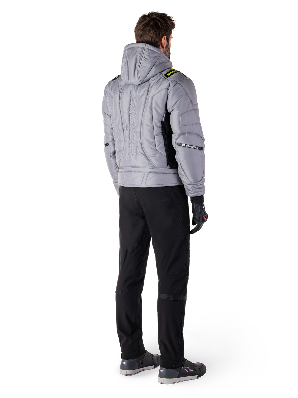 Alpinestars Mohobbs vandtæt jakke, Lunar Gray Lime Punch, set bagfra af quiltet motorcykeljakke i bomber-stil med hætte, med Alpinestars-ordmærke på ryggen, båret med sorte kørebukser og handsker, urban moto-streetwear