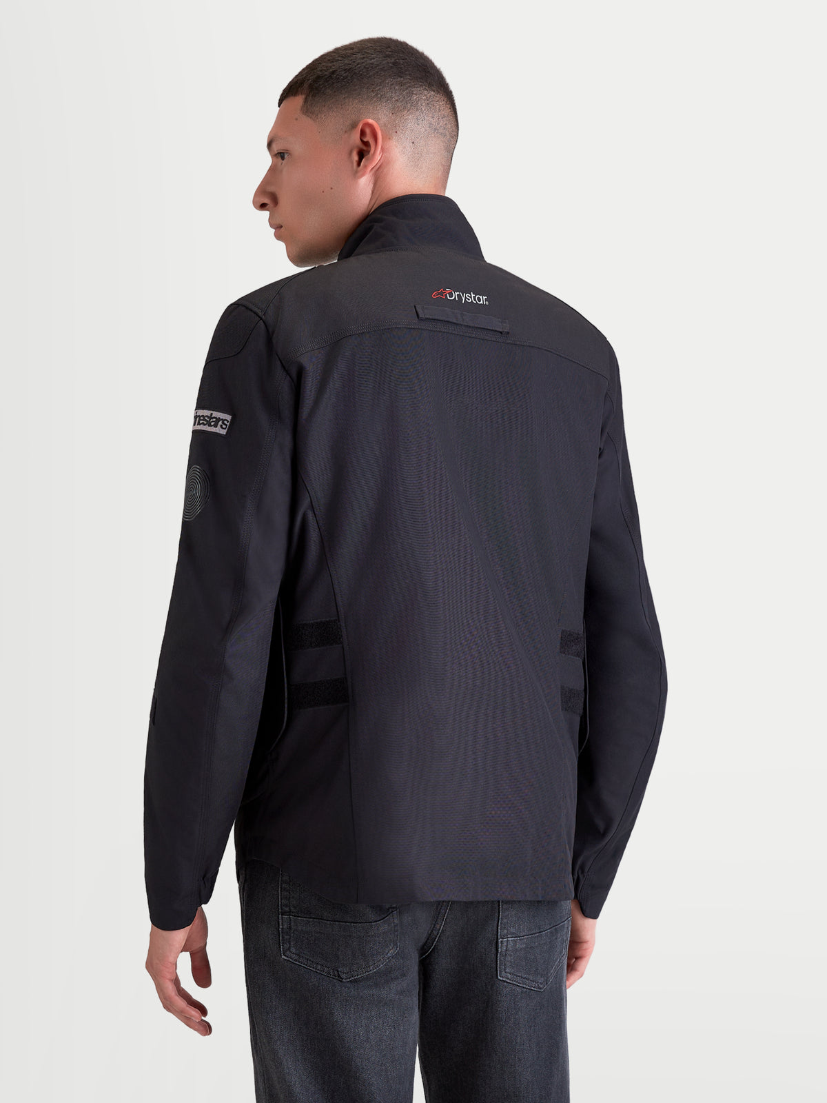 Alpinestars Altan Drystar Jacket, men's urban contemporary motorcycle textile jacket in black, rear profile view on a model wearing the waterproof riding jacket with Drystar technology and integrated warm collar