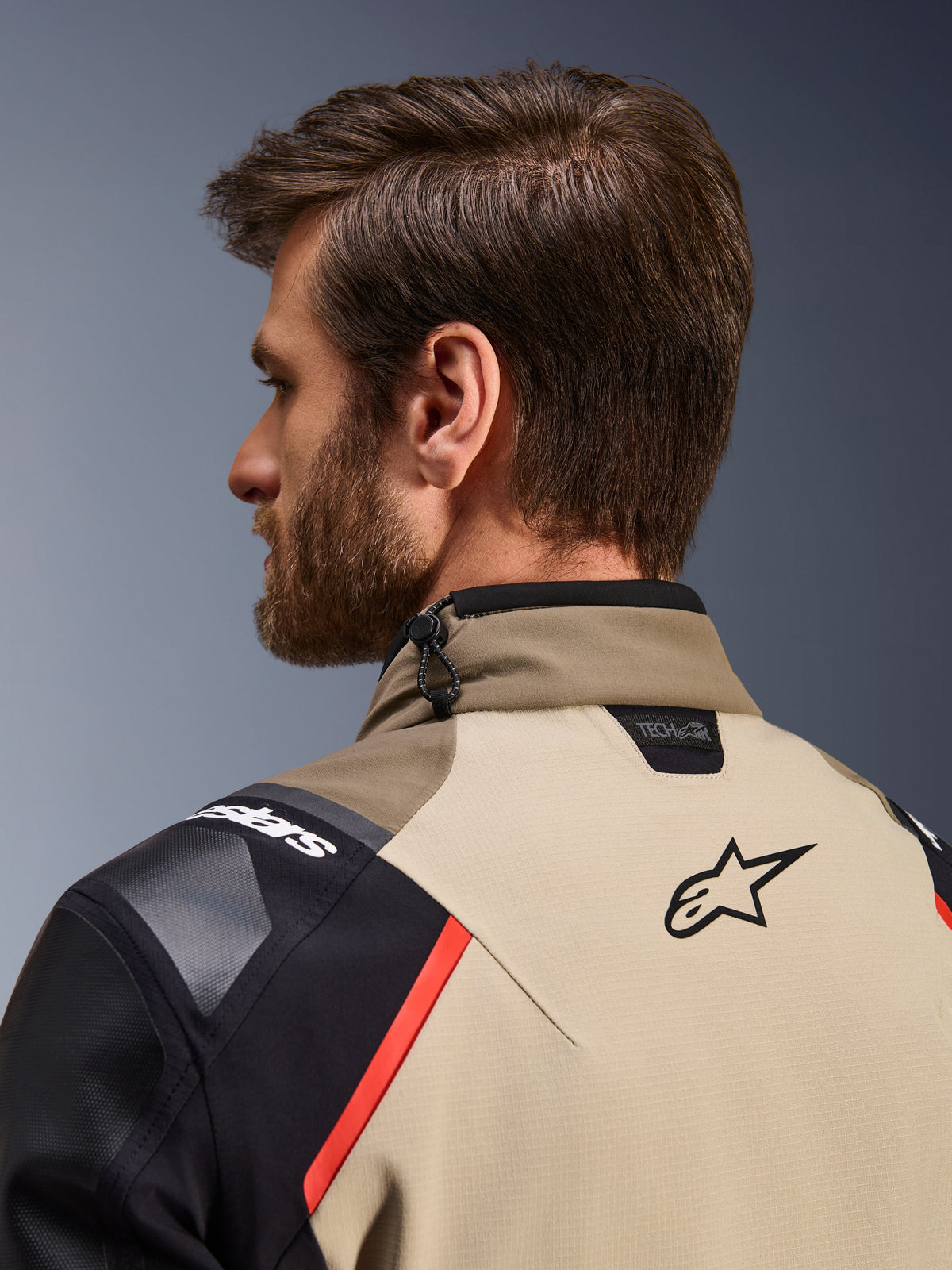 Alpinestars Andes Pro Drystar® XF-jakke i Walnut Aluminum, nærbillede bagfra, der viser kraven og de øverste skuldre, med Alpinestars-logo, Tech-Air-kompatibilitetsbranding, røde detaljer og et snoretrækssystem til justering i nakken.