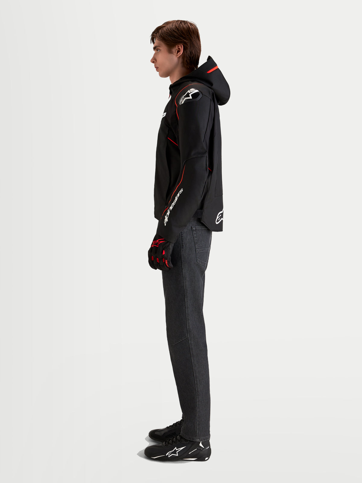 Alpinestars Zaca V2 Waterproof Jacket, Men's motorcycle sport riding jacket in Black and Red Fluo, featuring an integrated hood, DFS shoulder armor, and pre-curved sleeves worn by a model in profile