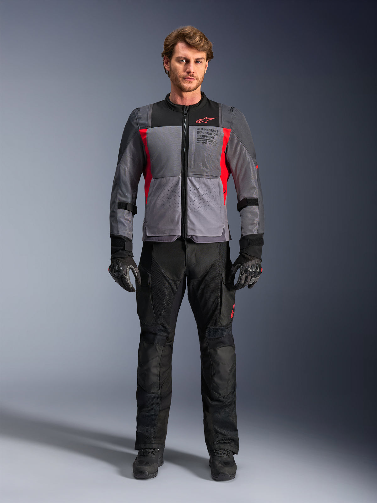 Alpinestars ST-2 Air Jakke, grå og rød motorcykeljakke til herrer med mesh-ventilation, båret af model med sorte bukser.