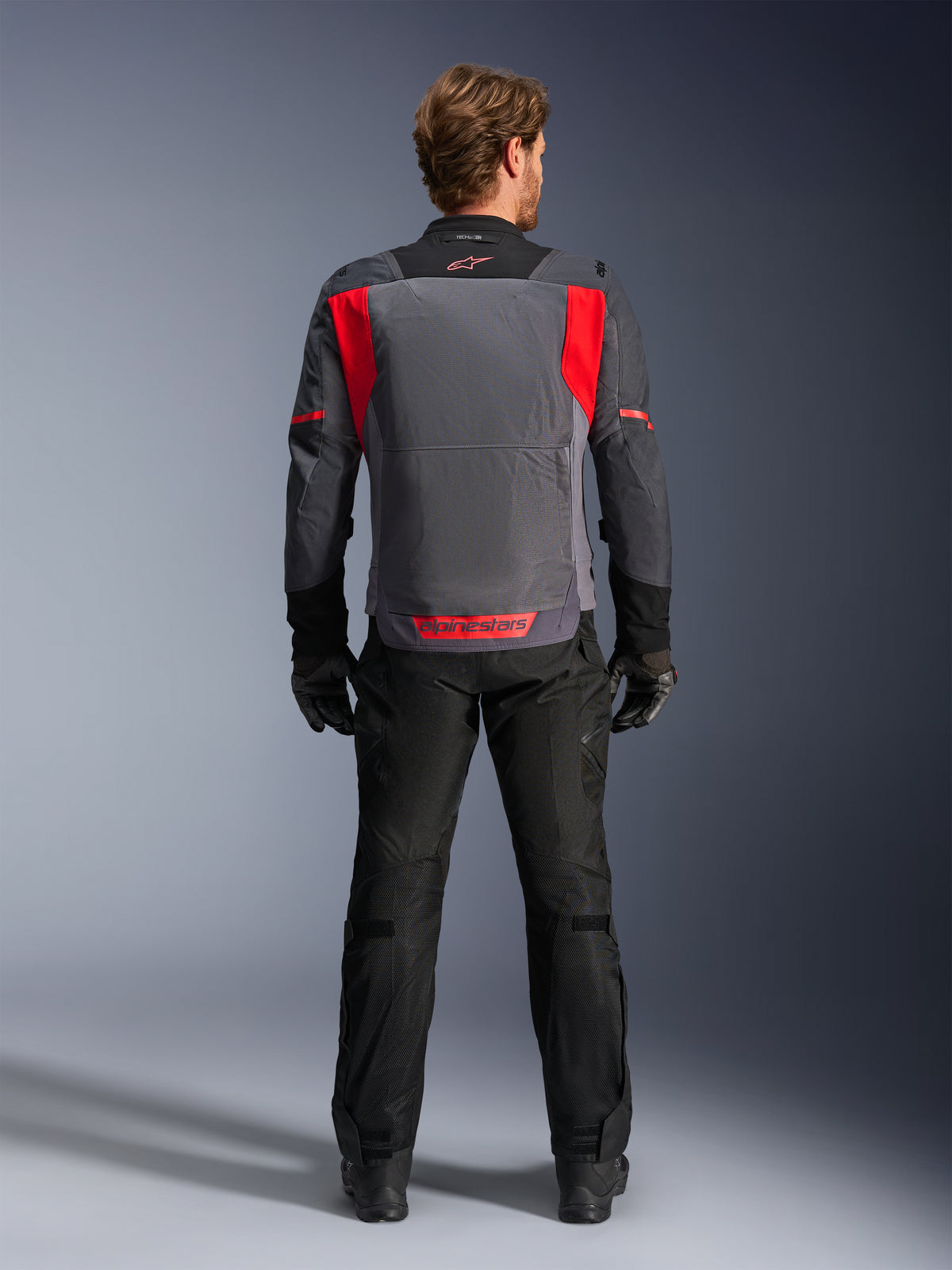 Alpinestars ST-2 Air-jakke, herre-motorcykeljakke til touring, grå og rød, set bagfra med mesh-ventilationspaneler.