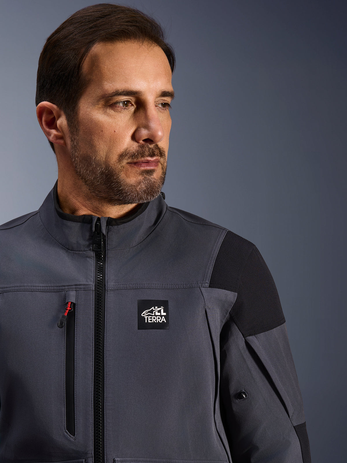 Alpinestars Maxdura Drystar®XF lamineret pansret skal, teknisk adventure-jakke, mørkegrå og sort, med 'ALL TERRA' branding på brystet, vandtæt brystlynlås med rød accent og højtydende tekstildesign til adventure-motorcykelkørsel