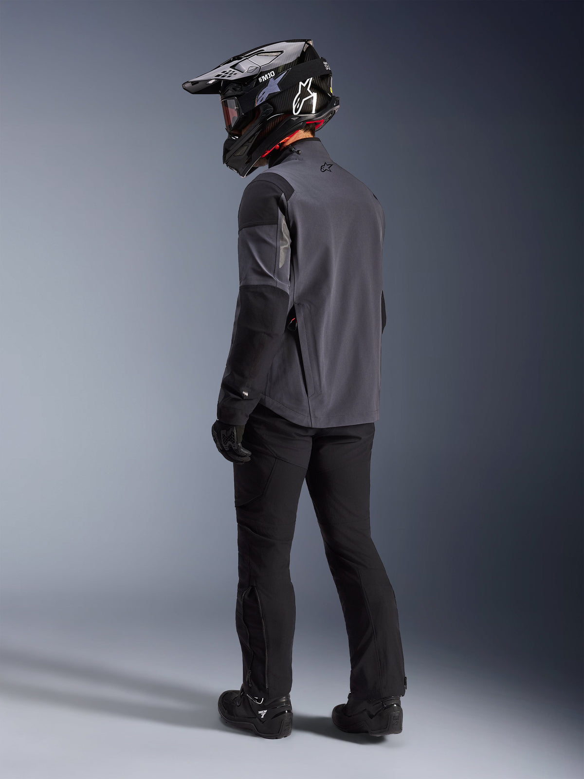 Alpinestars Maxdura Drystar®XF Laminated Armored Shell i Deep Gray Black, adventure-rytter set bagfra, komplet udstyrssæt med sorte motorcykelbukser, sort motocrosshjelm og sorte off-road støvler, teknisk køreudstyr til al slags vejr og dual-sport performance.