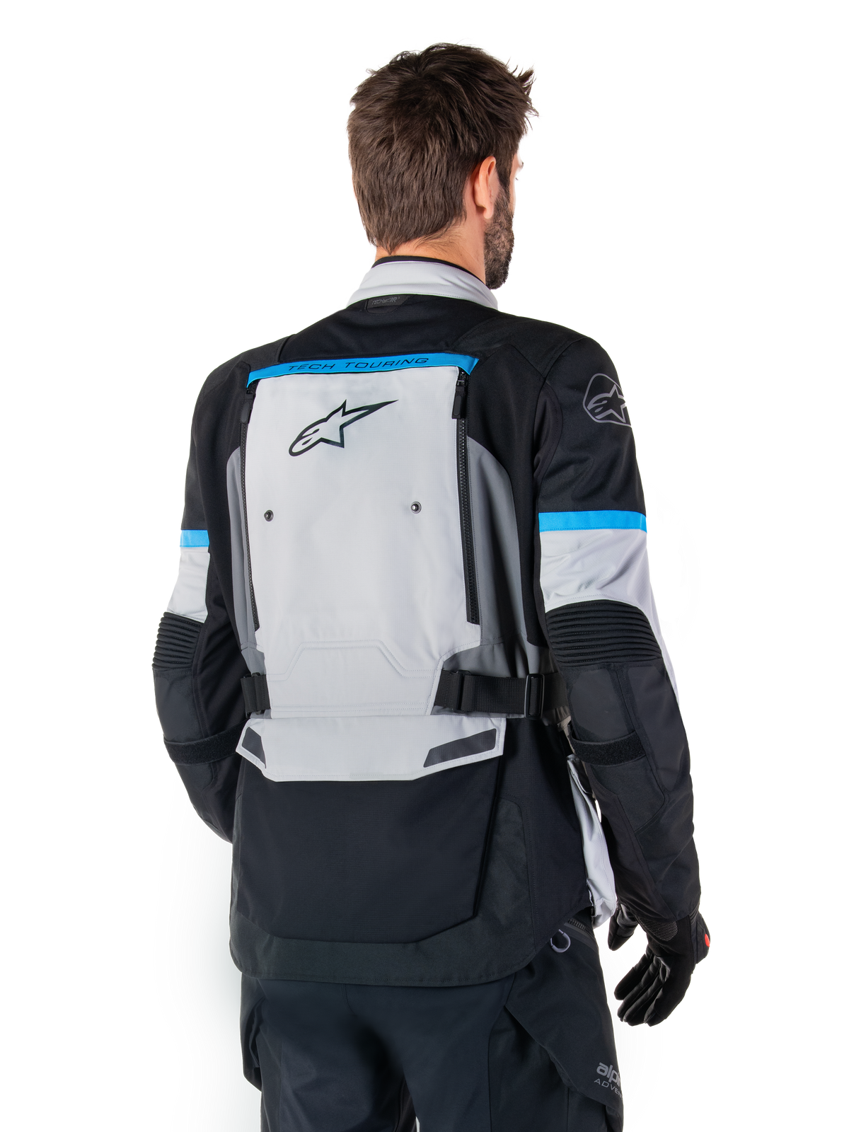 Alpinestars Bogota' Pro Drystar® jakke, adventure-motorcykeljakke til herrer, isgrå, sort og cyan, set bagfra i tekstil.