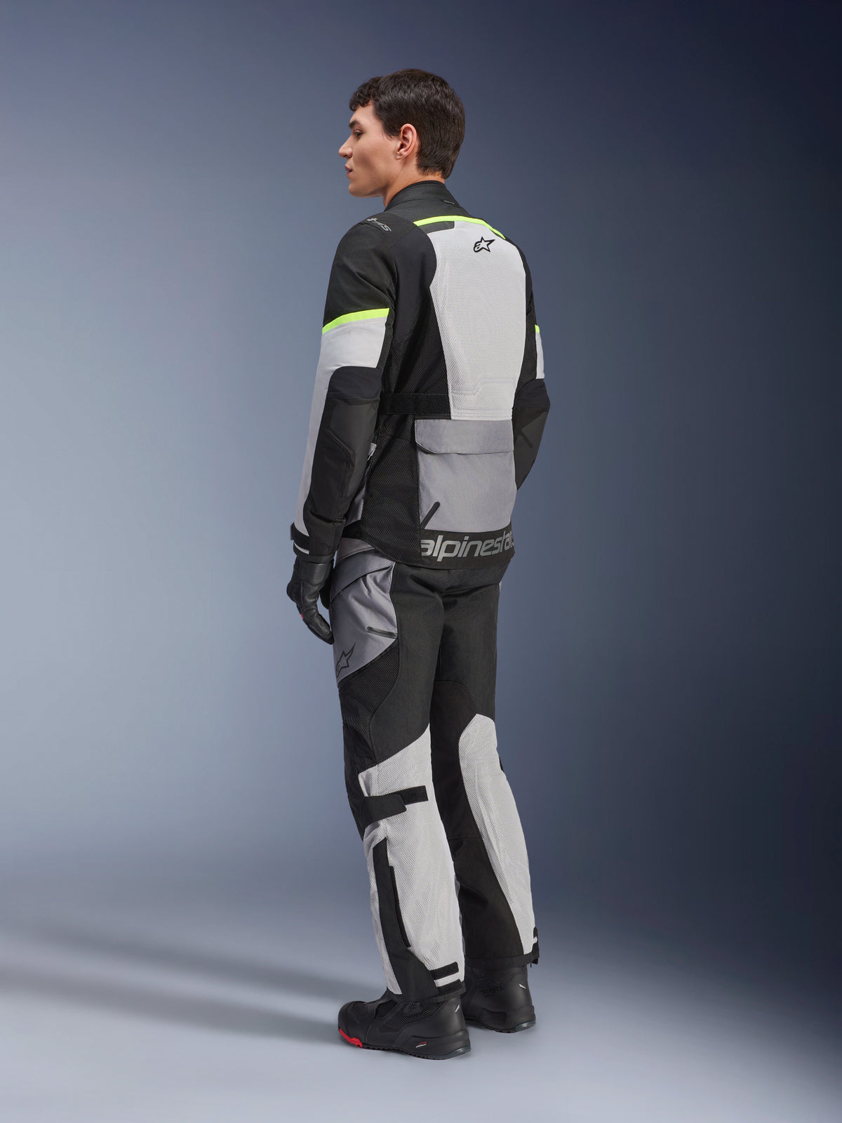 Alpinestars Andes Air Drystar® Jacket, touring motorcycle jacket, Ice Gray and Dark Gray with Black panels and neon yellow accents, worn with matching pants and gloves, rear three-quarter view showing mesh ventilation and Alpinestars branding.