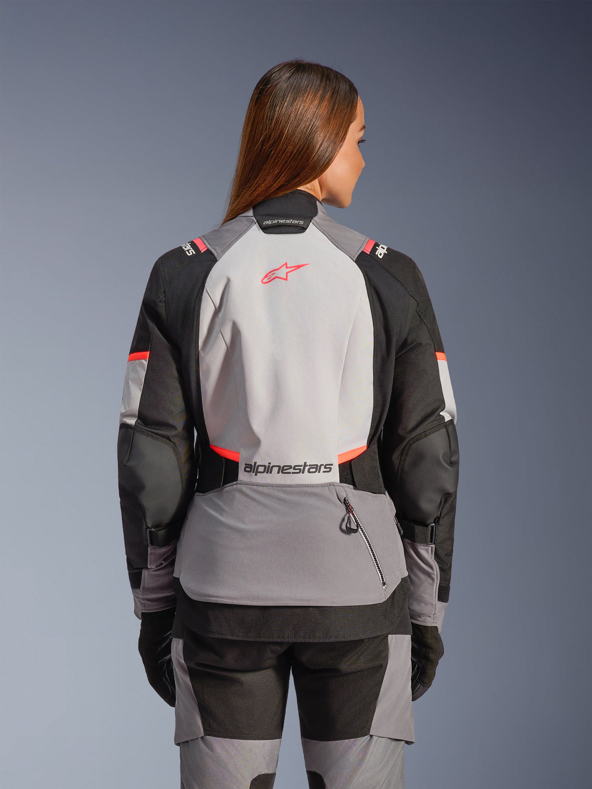 Alpinestars Stella Andes V4 Drystar® Jakke, dame-motorcykeljakke i grå og koral til adventure, set bagfra.