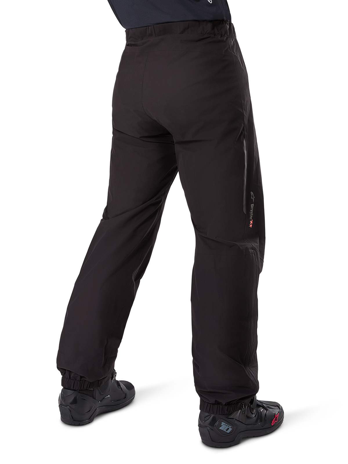 Alpinestars Amt-8 Stretch Drystar® XF Pant Liner, sort, set bagfra, viser den vandtætte liner båret over sorte motorcykelstøvler, med Drystar XF-branding på underbenet, elastiske ankelmanchetter og letvægtsstrækmateriale til adventure touring.