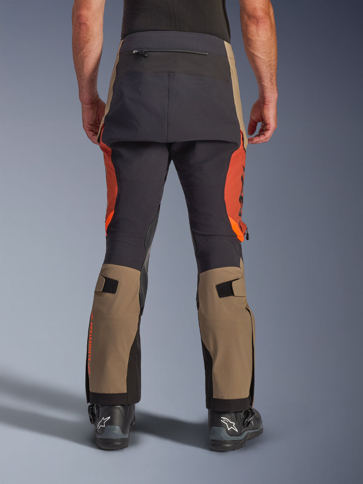 Alpinestars Halo Pro Drystar® XF laminerede bukser i Walnut Rust Black, set bagfra, adventure-motorcykelbukser med paneler i valnødbrun og rustorange, sort forstærkning i sædet, baglomme med lynlås og justerbare stropper til lægvolumen