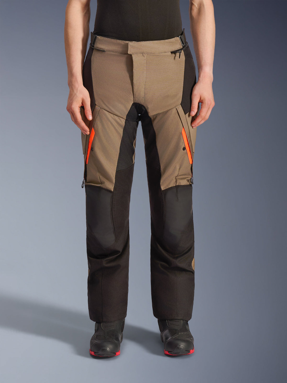 Alpinestars Andes V4 Drystar® bukser, adventure-motorcykeltouringbukser i Walnut og sort, med klare orange lynlåse på lårene, forstærkede sorte knæpaneler og holdbar tekstilkonstruktion til kørsel i al slags vejr.