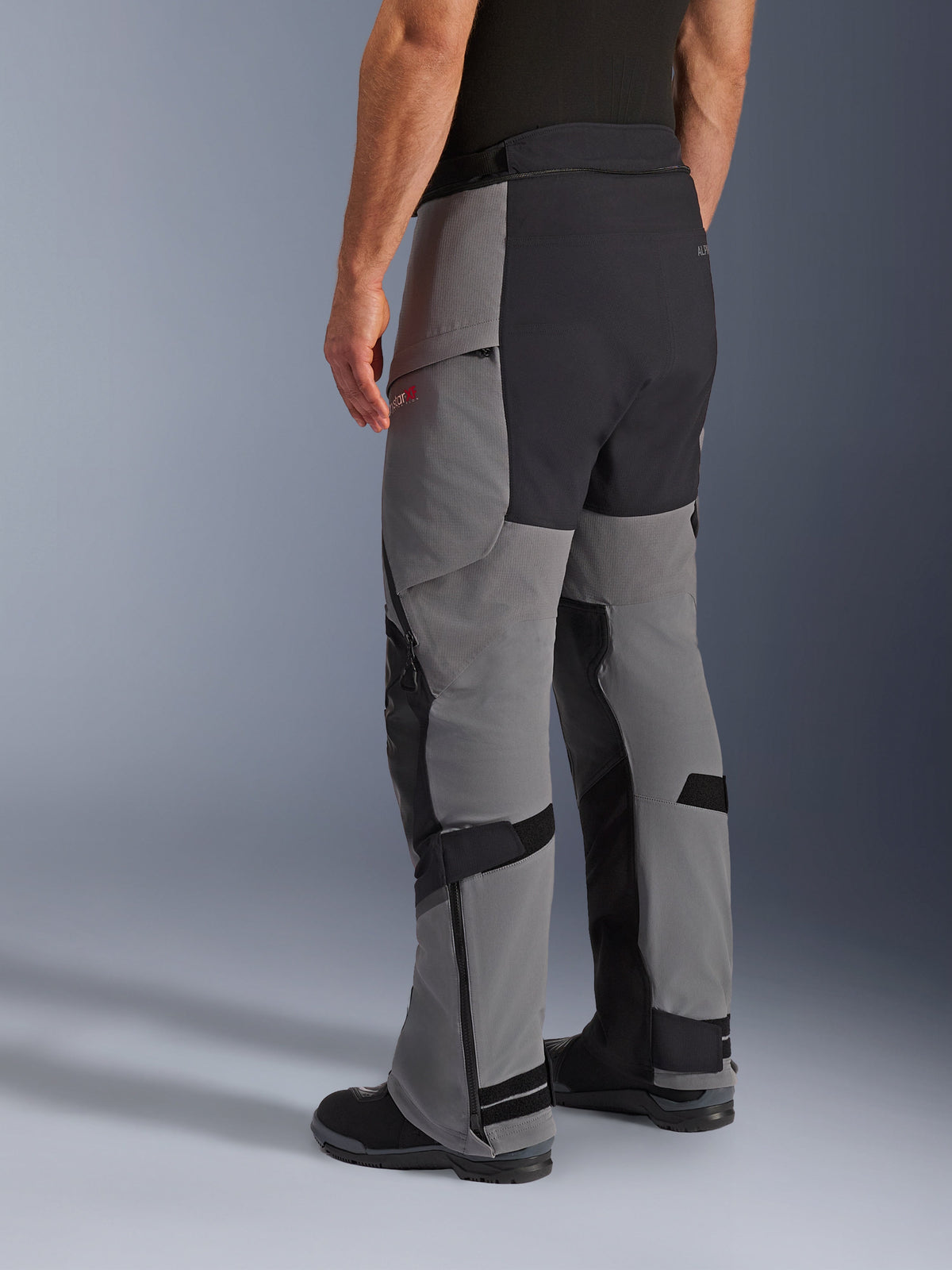 Alpinestars Andes Pro Drystar® XF bukser, adventure motorcykelbukser, mørkegrå og sort, trekvart visning bagfra, tekstilkonstruktion med sort forstærket sæde og indvendige benpaneler, lynlåse ved underbenene og justeringsremme