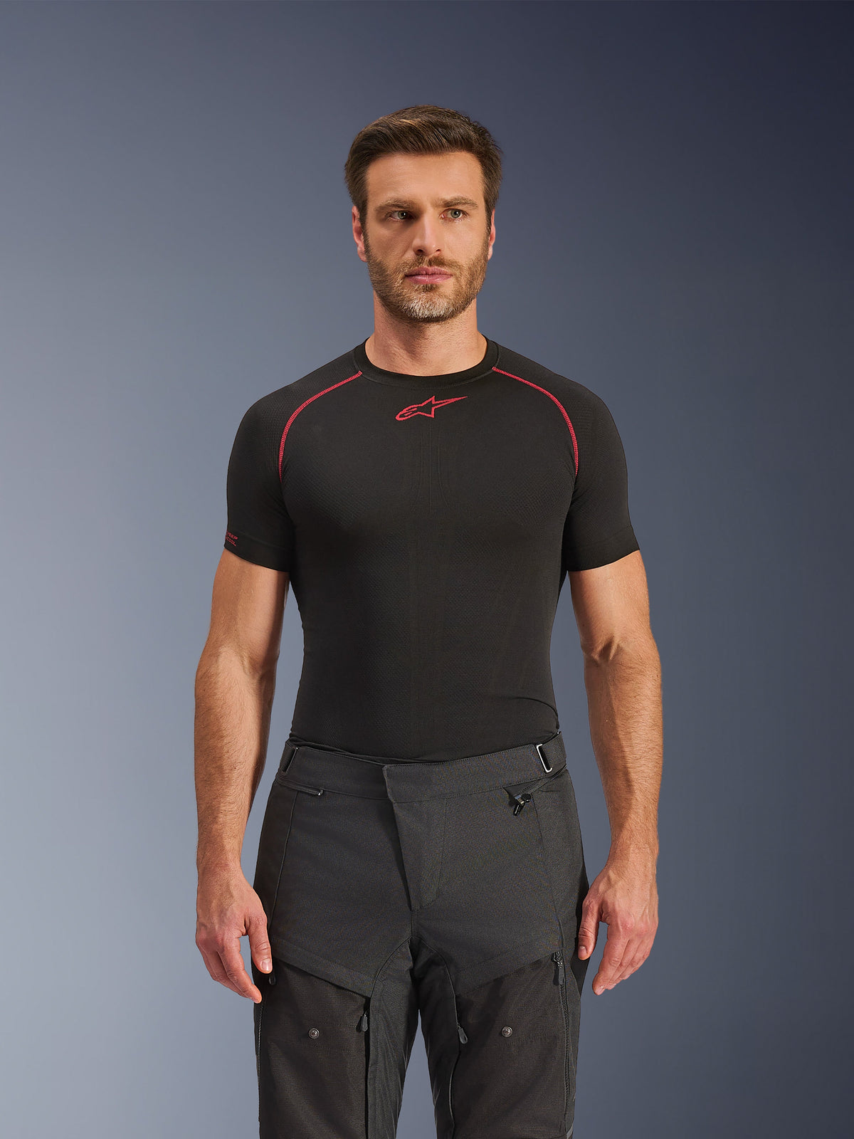 Alpinestars Cusco Drystar® bukser, adventure motorcykelbukser, sort, teknisk tekstilkonstruktion med lynlåsventilation og ripstop-paneler, båret af en mandlig model med en sort Alpinestars base layer-trøje for et komplet adventure-kørerlook