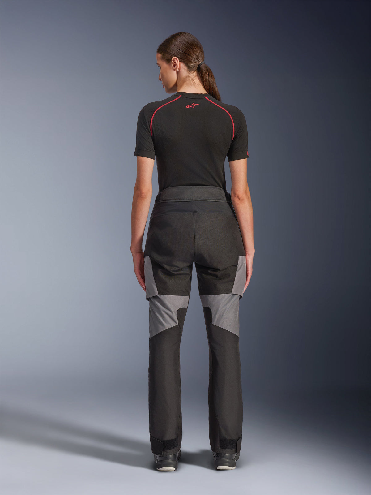 Alpinestars Stella Andes V4 Drystar® bukser, motorcykelbukser til damer, sort og mørkegrå, set bagfra med grå ripstop-forstærkninger og ergonomisk design, båret med et sort teknisk basislag, adventure touring køreudstyr