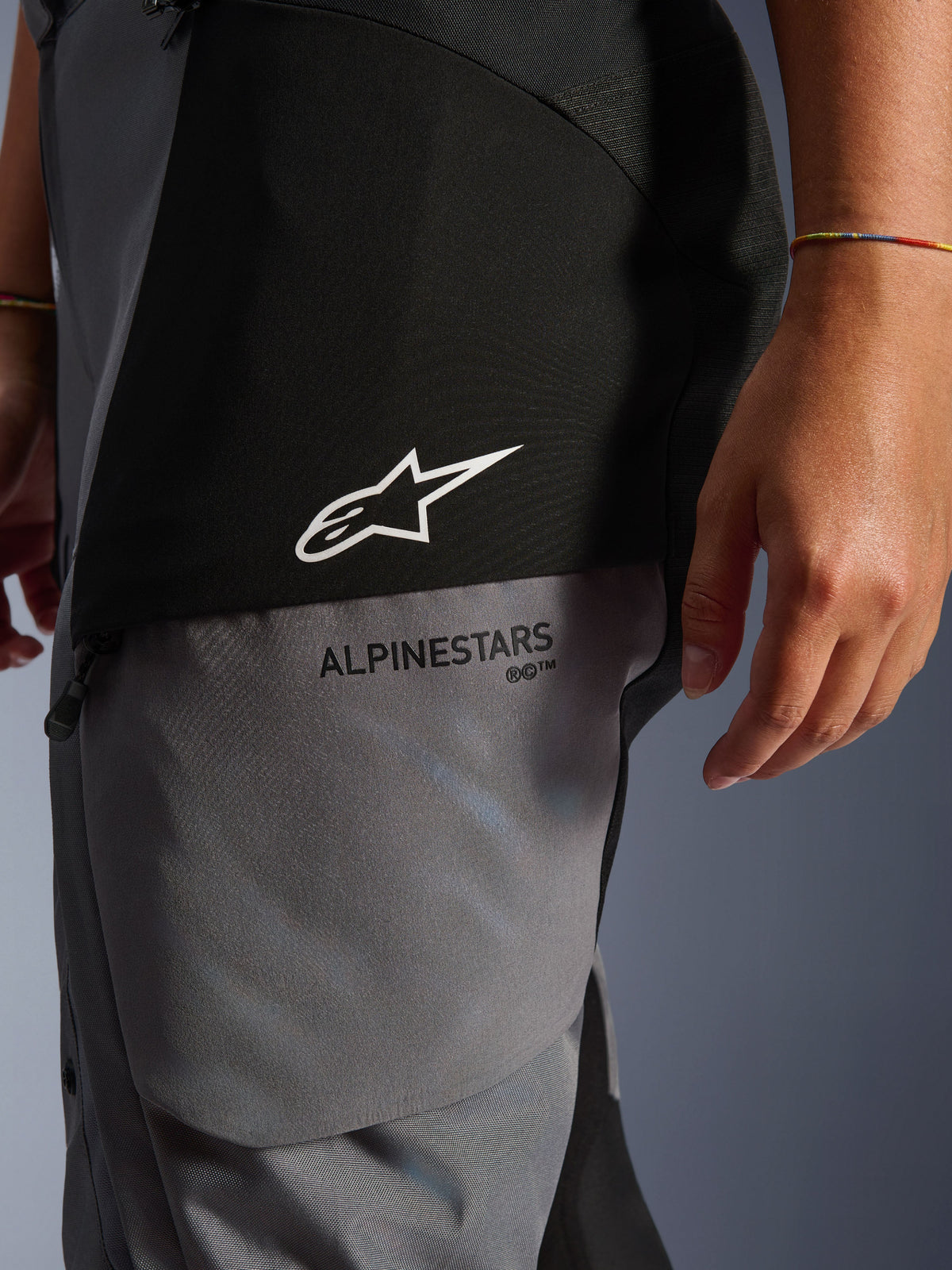 Alpinestars Stella Andes V4 Drystar® bukser til damer, sort og mørkegrå, nærbillede af det øverste lår med hvidt stjernelogo og sort Alpinestars-branding, holdbart adventure touring tekstilmateriale