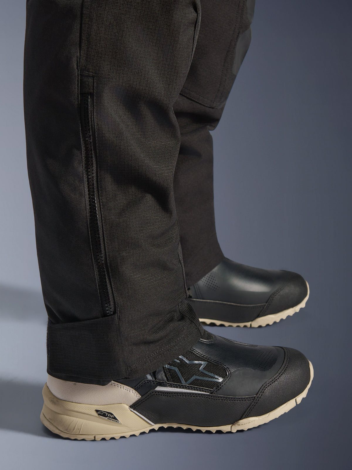 Alpinestars Stella Andes V4 Drystar® bukser, detalje af det sorte underben med lodret lynlås til pasform over støvler, slidstærk tekstilkonstruktion, adventure-motorcykeludstyr til kvinder.