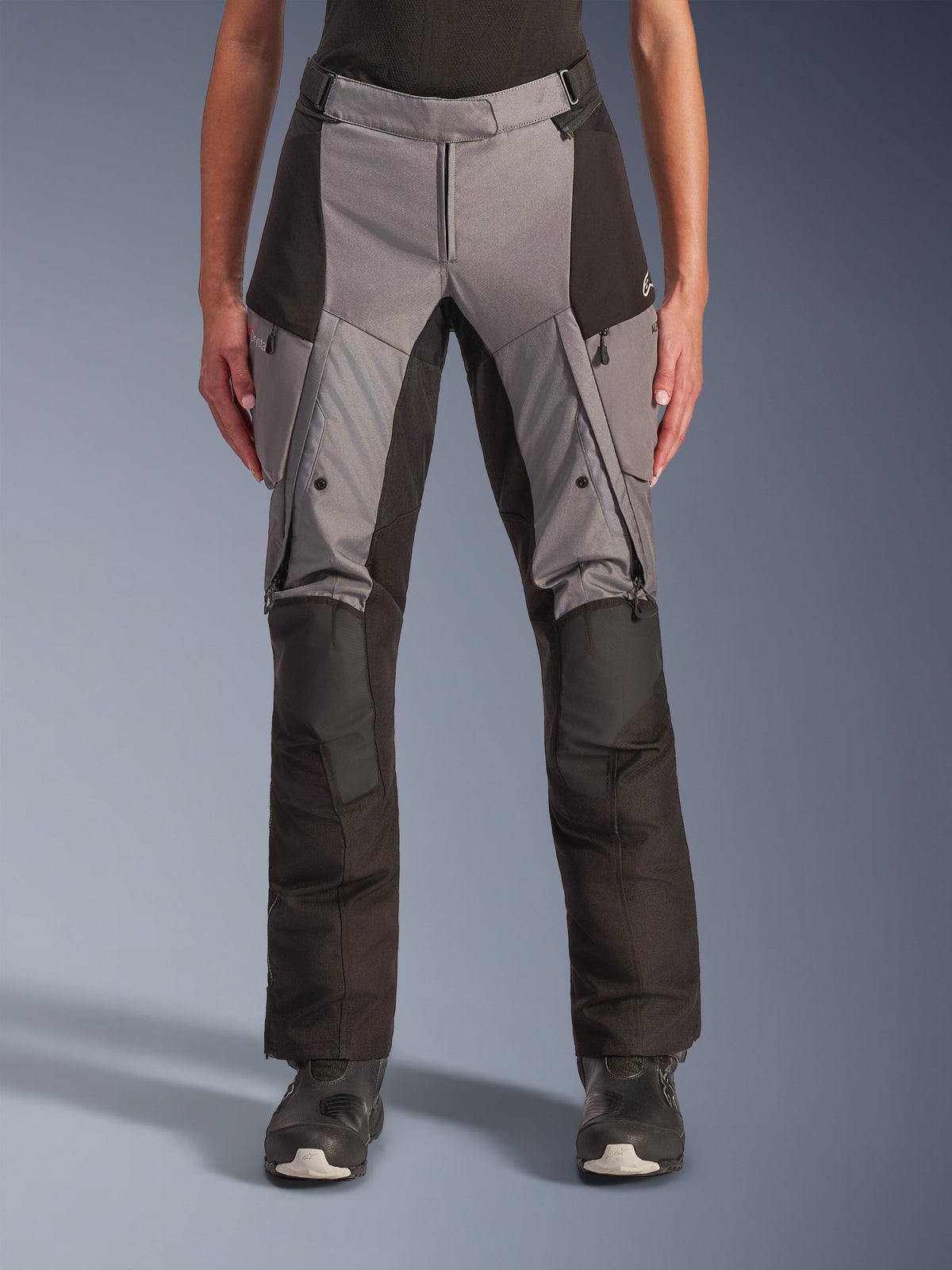Alpinestars Stella Andes V4 Drystar bukser, motorcykel-touringbukser til kvinder, grå og sort, set forfra med ventilationsåbninger med lynlås på lårene, cargolommer og forstærkede knæpartier, designet til adventure-kørsel i al slags vejr