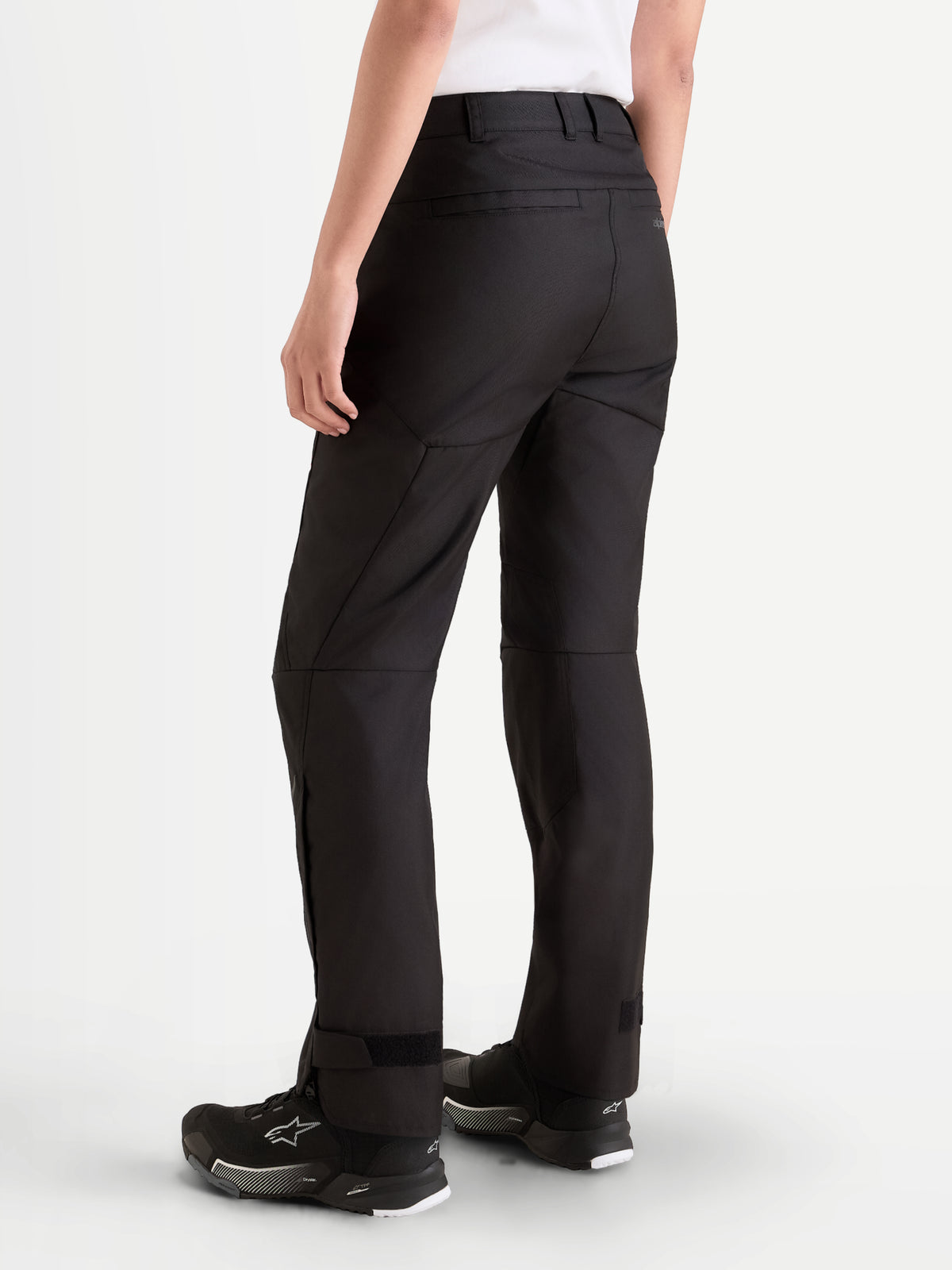 Alpinestars Stella C-1 Waterproof bukser, vandtætte motorcykelbukser til kvinder i sort, set bagfra med holdbar polyfabric-konstruktion, bæltestropper og lige ben båret af en model