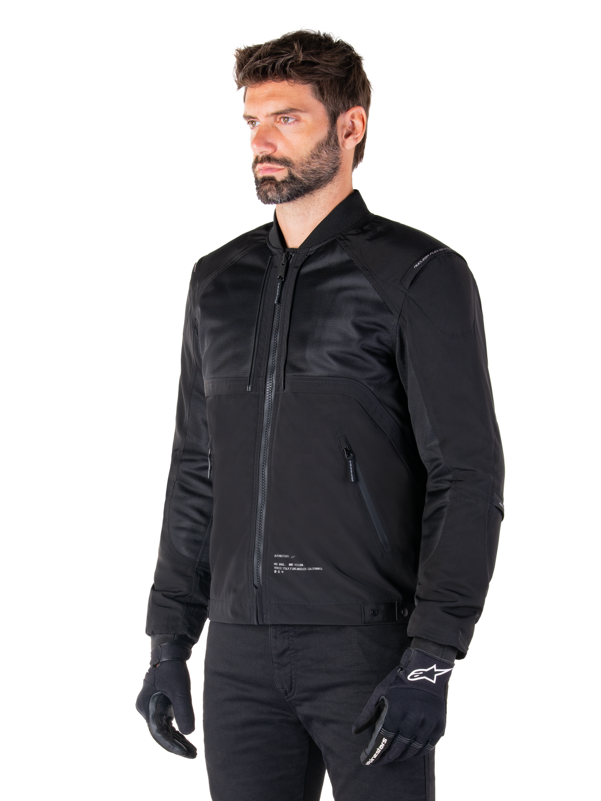 Alpinestars Mootant Waterproof Parka, modulær sort motorcykeljakke vist i sin bomber-konfiguration med mesh-paneler på overkroppen og en ribbet krave, bæres af en model med sorte kørehandsker og bukser, moderne urban streetwear-stil.