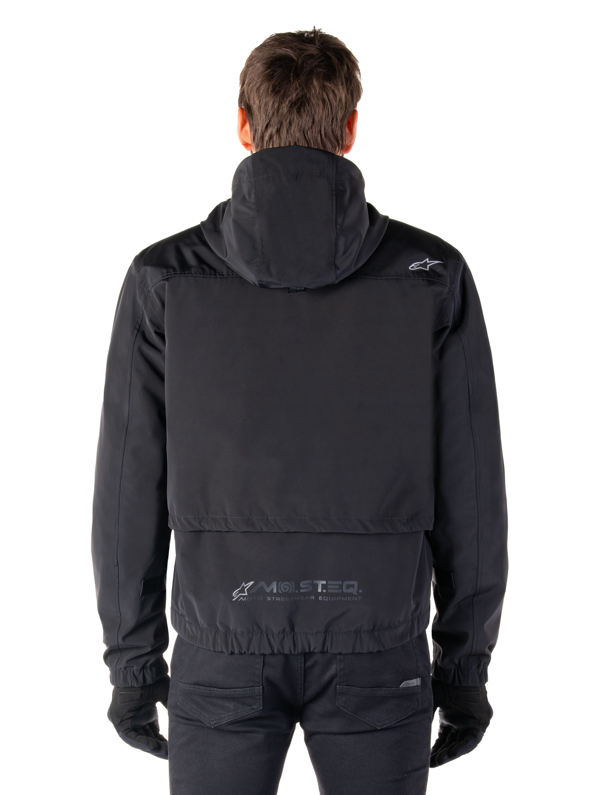Alpinestars Mootant vandtæt parka, sort motorcykeljakke, set bagfra med hættedesign, lille Astar-logo på skulderen og reflekterende MO.ST.EQ.-branding nederst på ryggen
