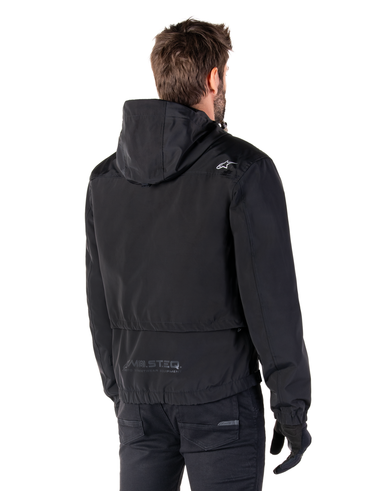 Alpinestars Mootant Vandtæt Parka, sort motorcykeljakke, set bagfra med hættedesign, hvidt logo på skulderen og MO.ST.EQ. reflekterende branding på lænden, moderne urbant køreudstyr