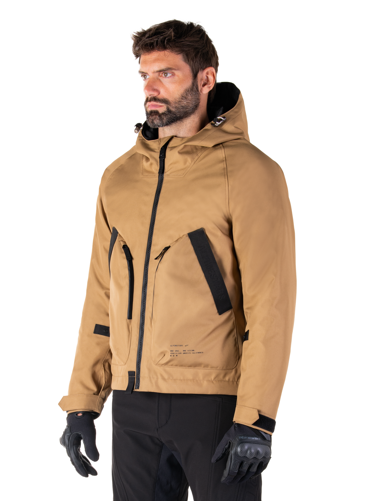Alpinestars Morush Waterproof Parka, Utility Brown, male model wearing parka with black riding gloves and black pants, minimalist streetwear-inspired design featuring a stormproof hood and large front pockets, waterproof motorcycle apparel