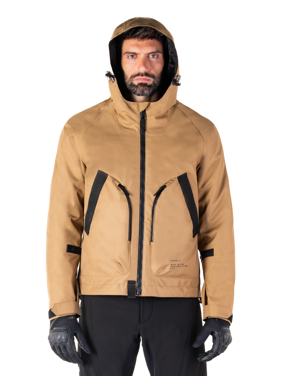 Alpinestars Morush Waterproof Parka, Motorcycle Jacket, Utility Brown, hooded streetwear-inspired design with large black-accented front pockets, worn with black riding gloves and pants, urban contemporary motorcycle gear